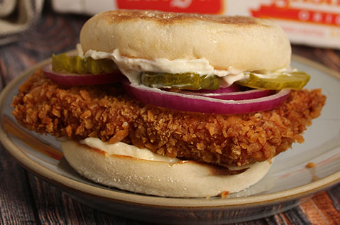 SANDWICH WITH A LARGE SLAB OF MEAT PLUS PICKLES AND ONIONS
