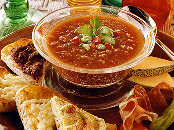 GARNISHED RED SOUP SURROUNDED BY SLICED BAYS
