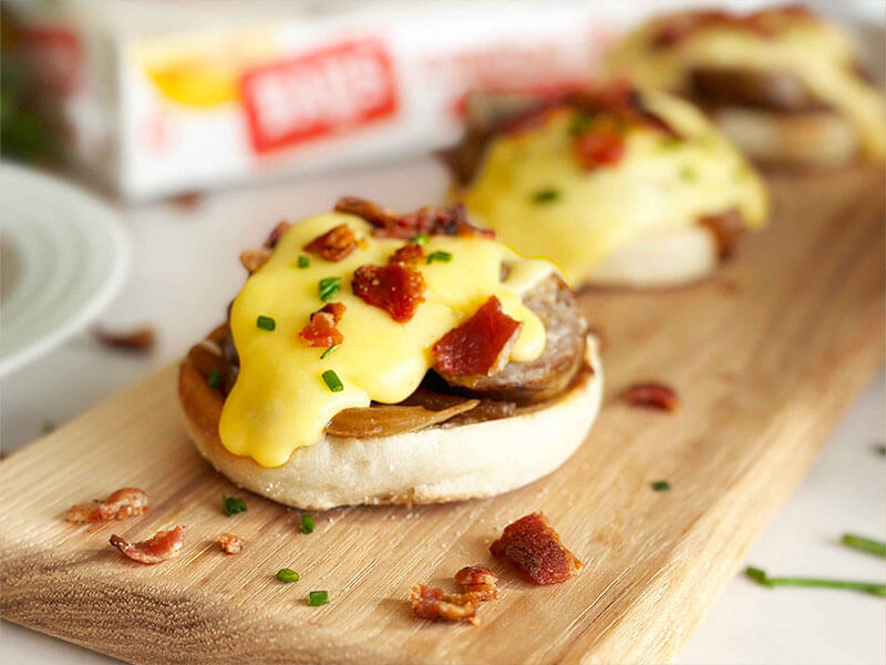bays on a wood board with sausage melty cheese and bacon