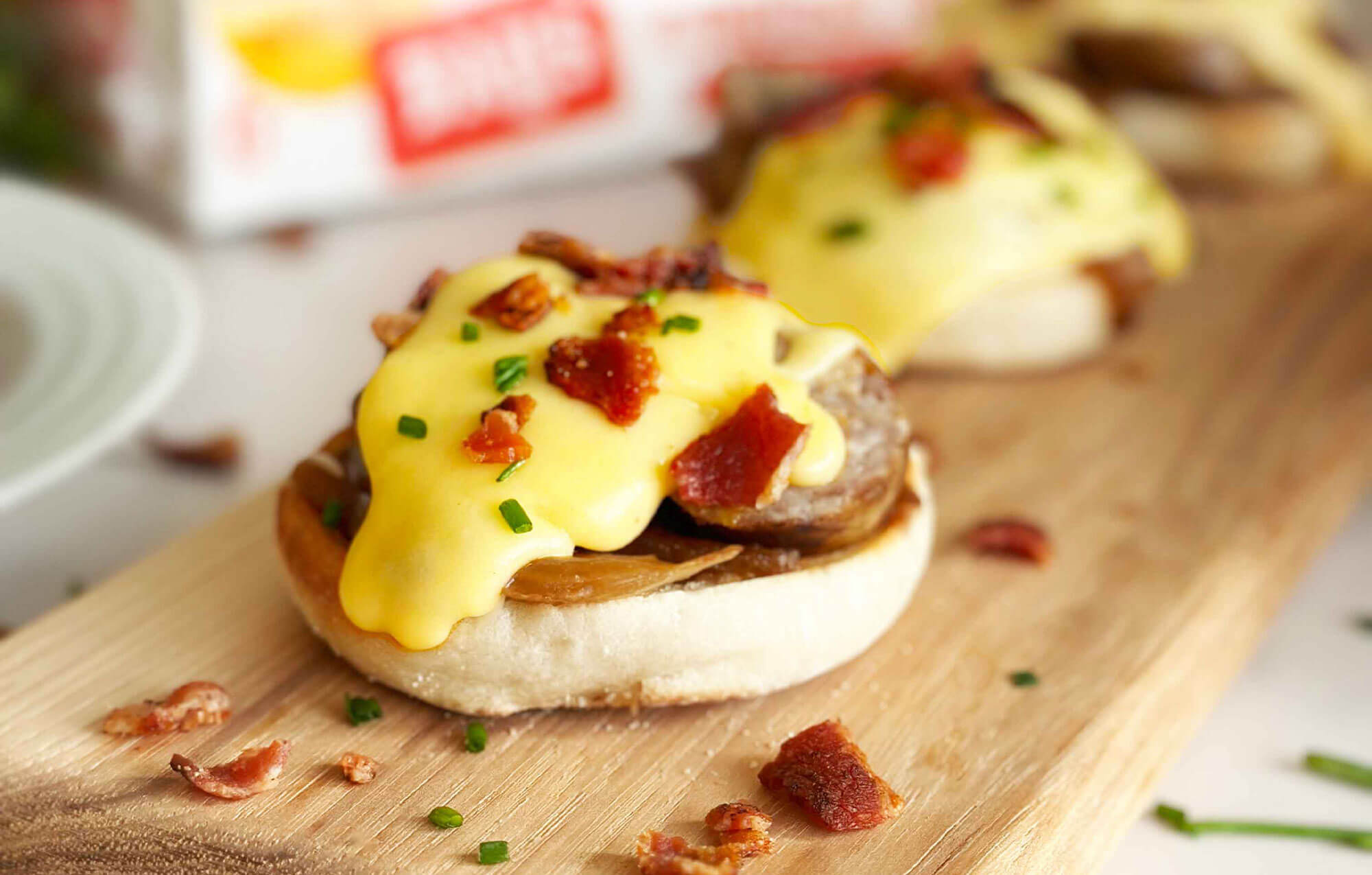bays on a wood board with sausage melty cheese and bacon