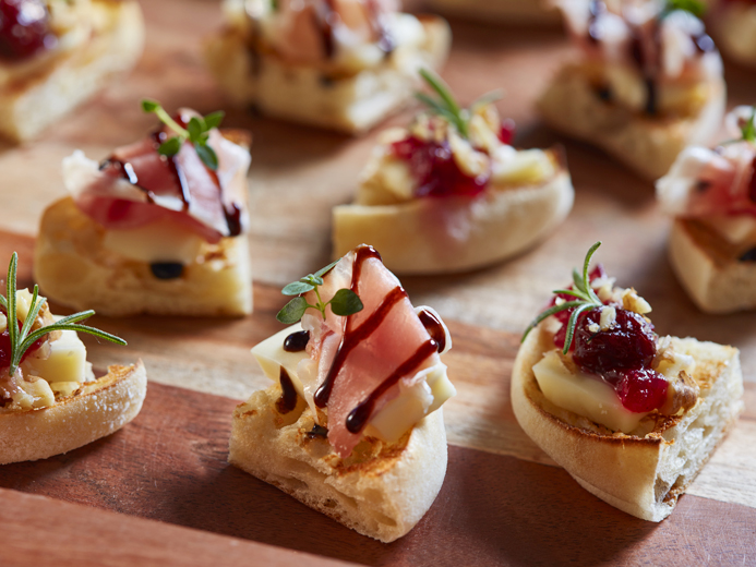 SMALL WEDGES OF BAYS WITH DIFFERENT MEATS FRUITS AND DRIZZLES
