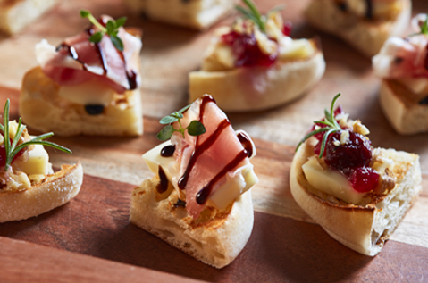 SMALL WEDGES OF BAYS WITH DIFFERENT MEATS FRUITS AND DRIZZLES
