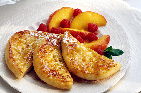 English muffin quarters neatly placed alongside fruit on a plate