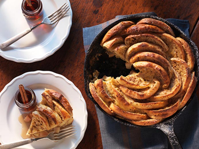 BAYS ARRANGED IN A CAST IRON PAN LIKE A FLOWER WITH A SLICE CUT ON A PLATE NEXT TO IT