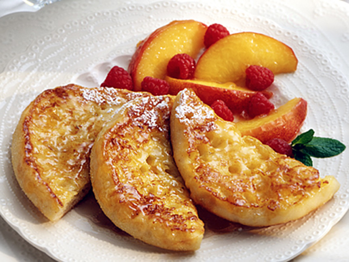 English muffin quarters neatly placed alongside fruit on a plate