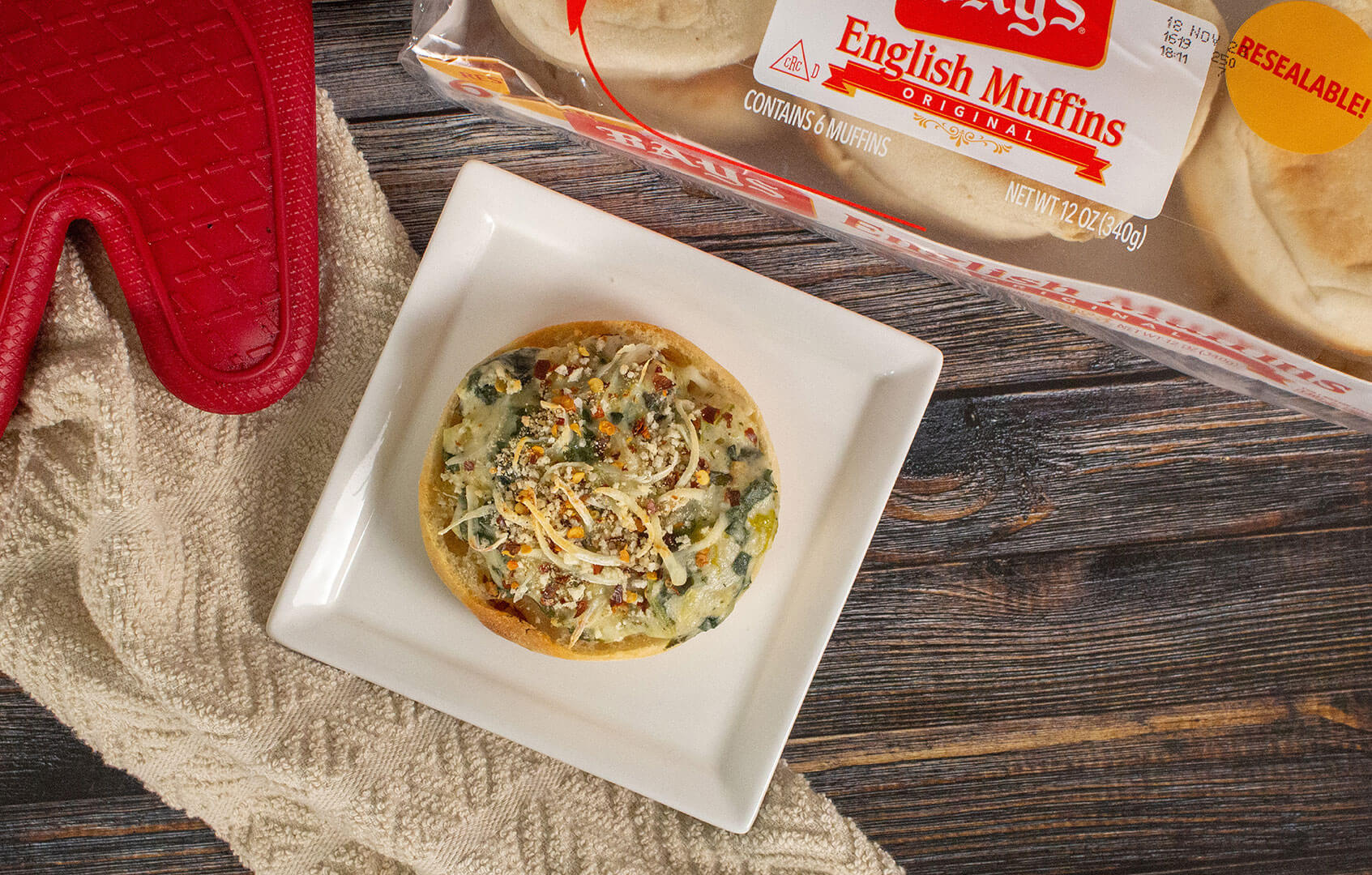 bays topped with a green and white spread and grated cheese