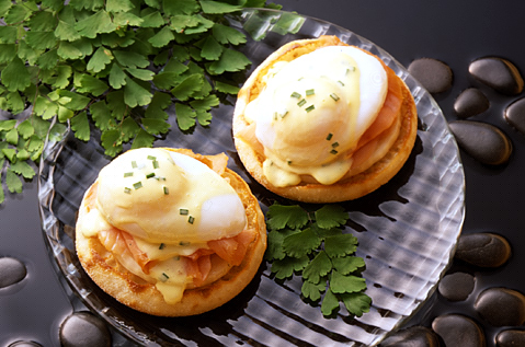 TWO BAYS TOPPED WITH COOKED FISH POACHED EGGS AND HOLLADAISE SAUCE