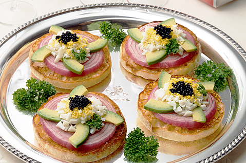 FOUR BAYS ENGLISH MUFFINS TOPPED WITH PERFECT ONION RINGS, AVOCADO IN A SPIRAL PATTERN AND A DALLOP OF CAVIAR