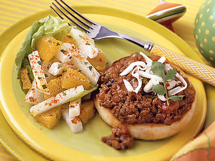 BAYS TOPPED WITH COOKED AND SEASONED GROUND BEEF NEXT TO FRUIT AND VEGGIES