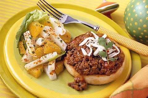 BAYS TOPPED WITH COOKED AND SEASONED GROUND BEEF NEXT TO FRUIT AND VEGGIES