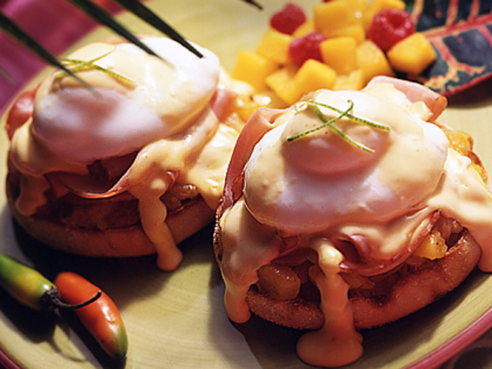 BAYS COVERED IN HAM, EGG, AND WHITE SAUCE NEXT TO HOT PEPPERS