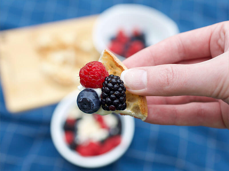 WEDGE OF BAYS WITH A RASPBERRY BLUEBERRY AND BLACKBERRY ON IT