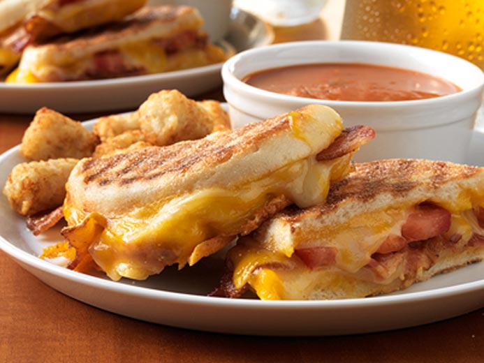grilled sandwich with soup in the background