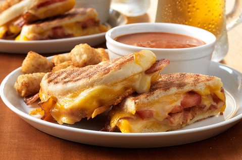 grilled sandwich with soup in the background